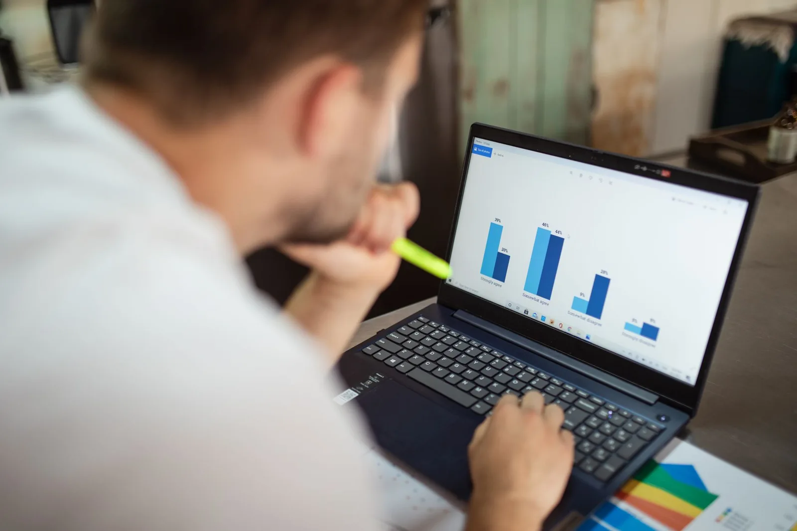 Analyst reviewing a bar chart on a laptop