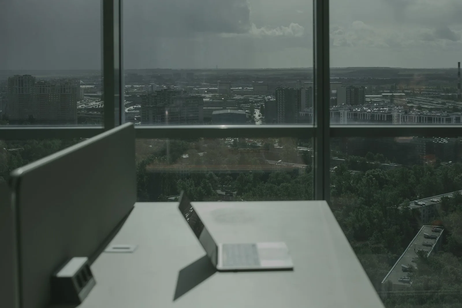 Desk facing floor-to-ceiling windows overlooking a city
